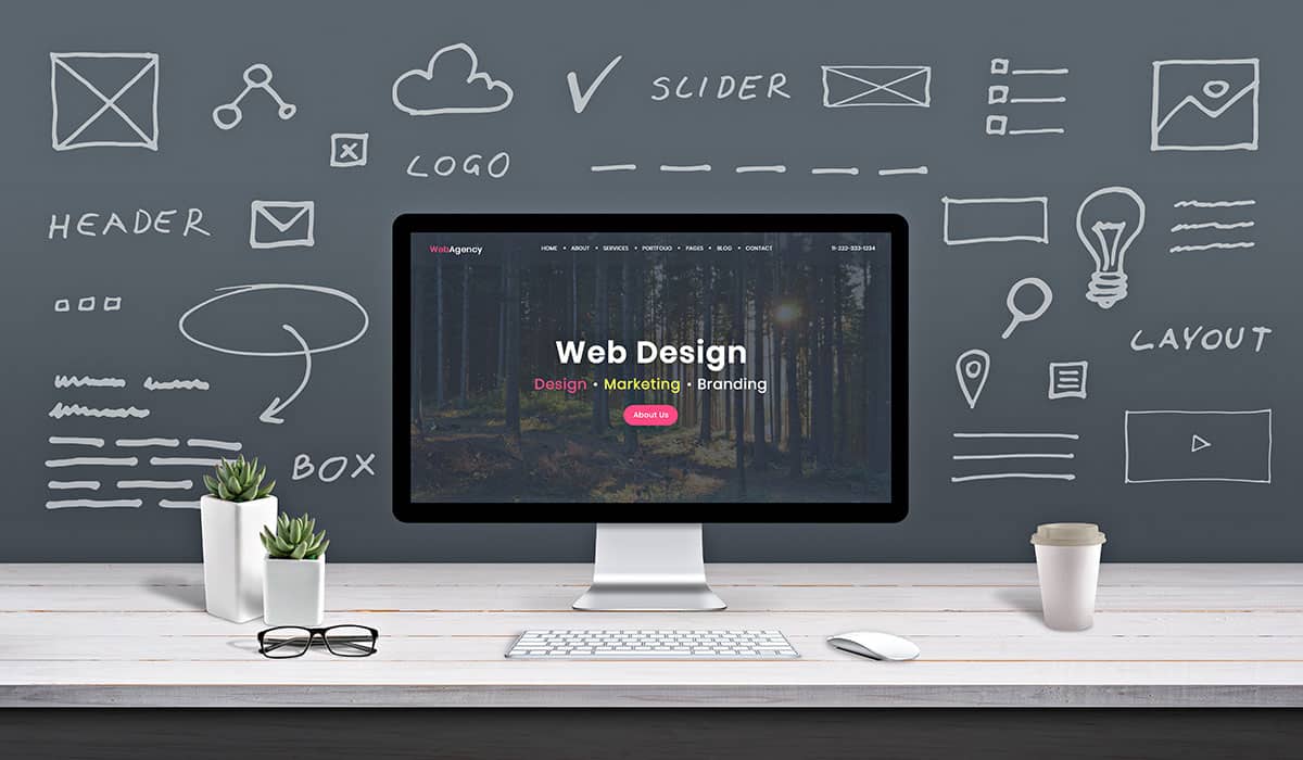 Web design concept with a desktop in front of a chalkboard background
