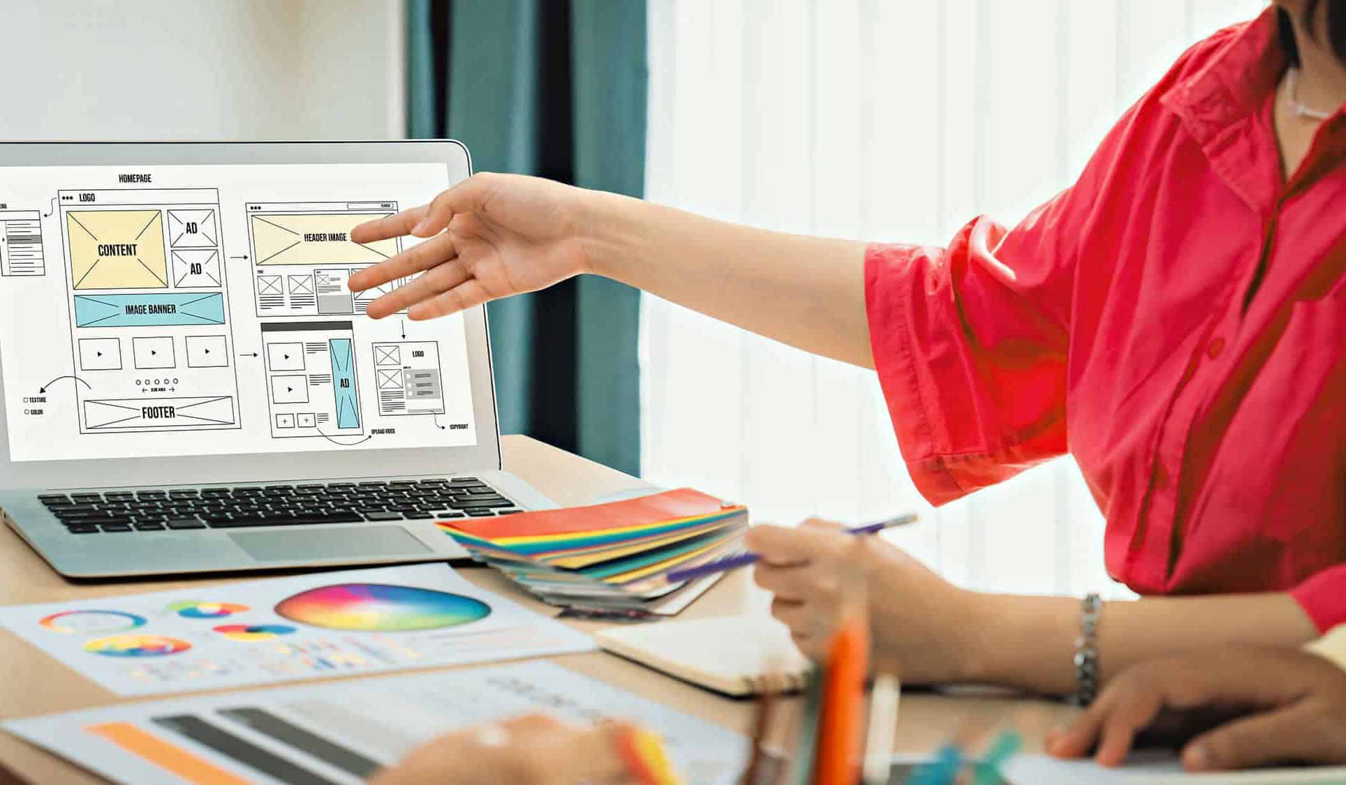 Web designer discussing website layout on laptop screen