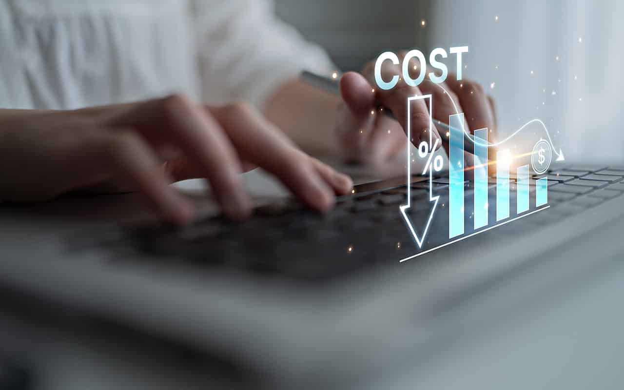 Person typing with cost decrease graph overlay