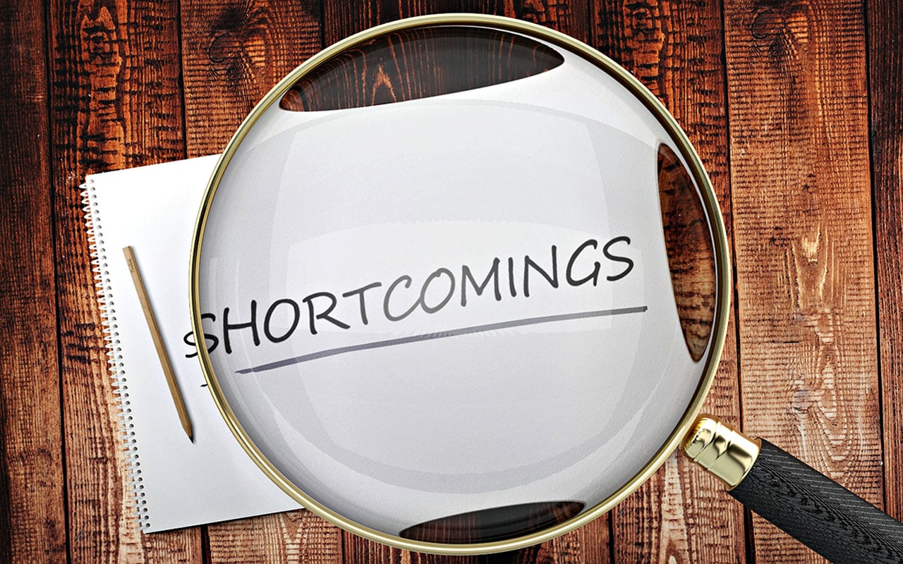 Magnifying glass highlighting the word 'shortcomings' on paper