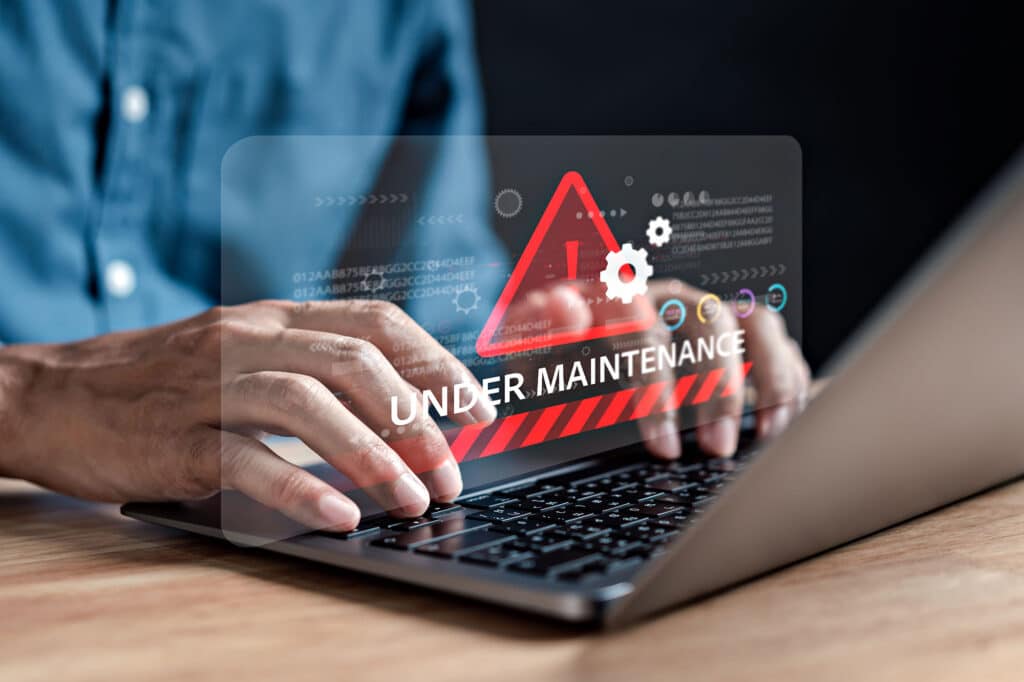 Under maintenance display on laptop showing warning symbol