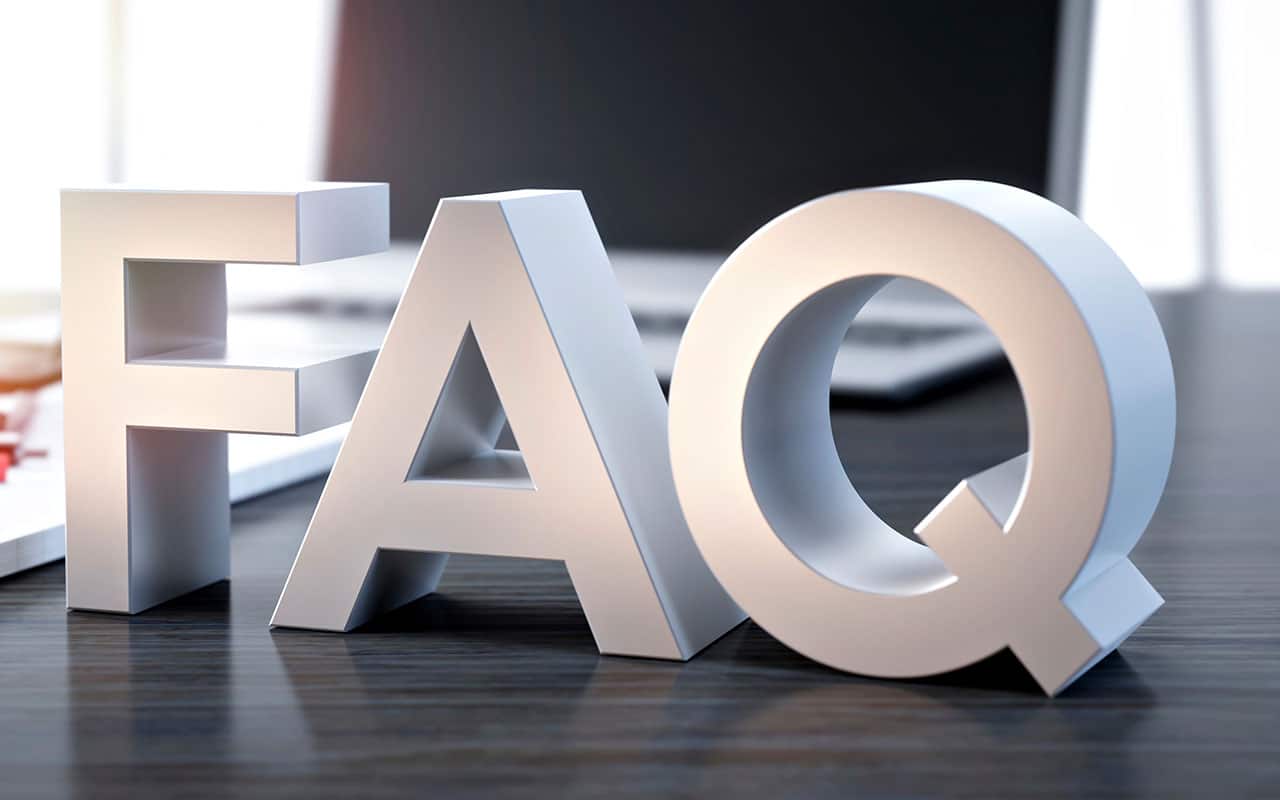 FAQ letters on desk with laptop in background